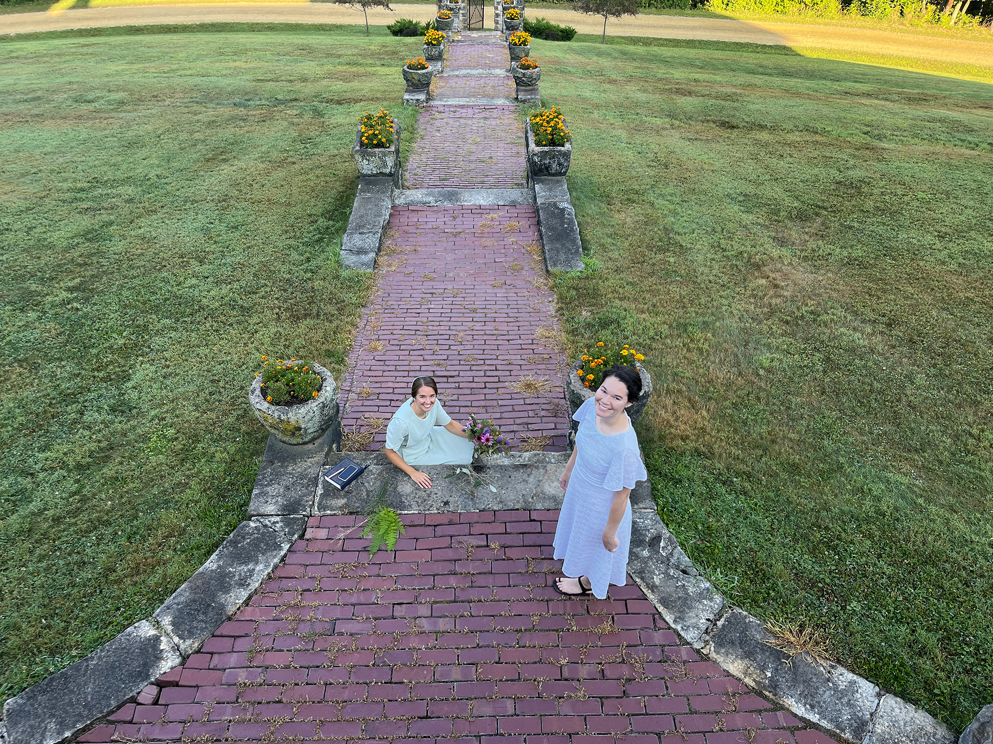 Two women on the front walk of a mansion