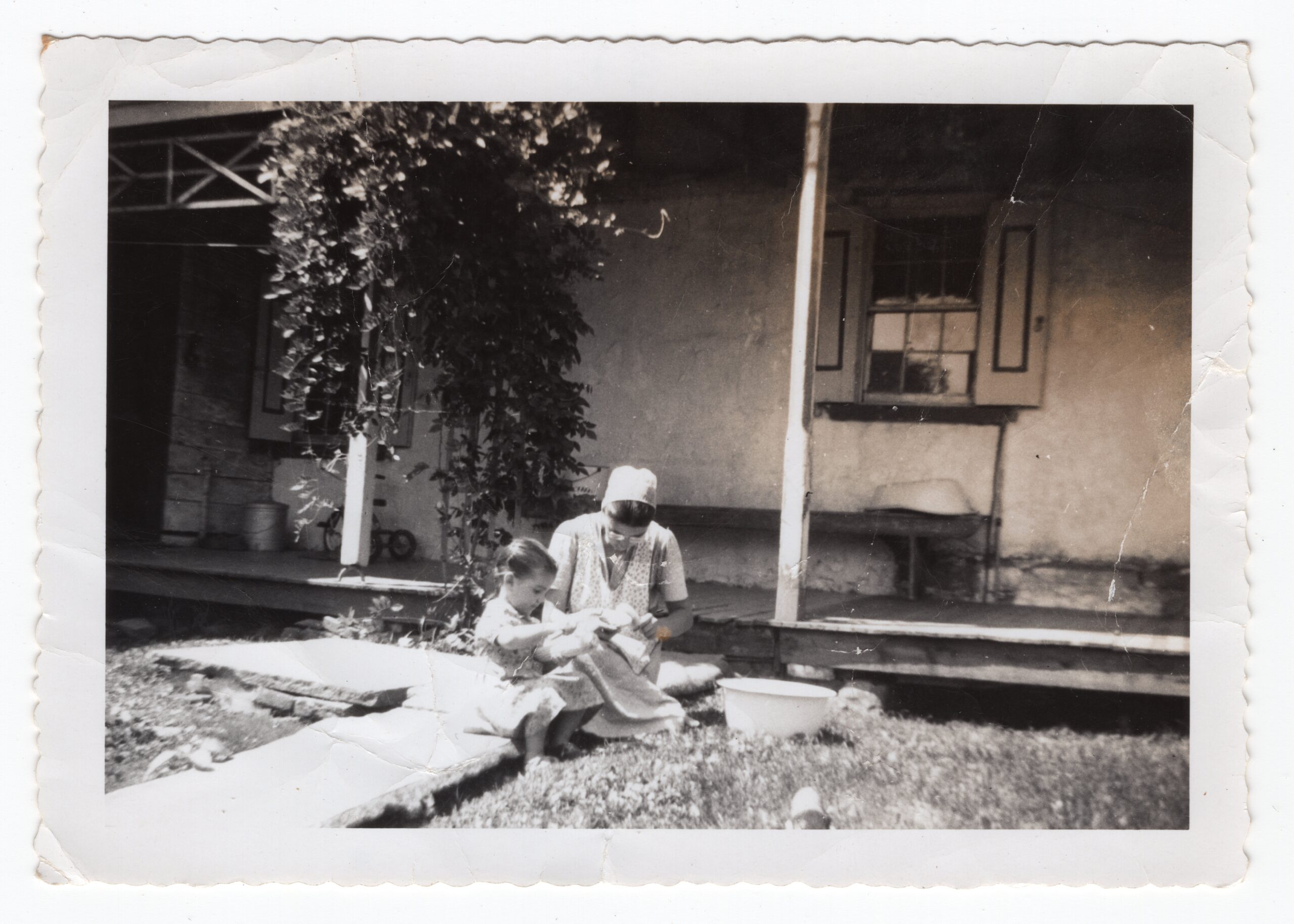 Old photo of young woman doing corn with child.